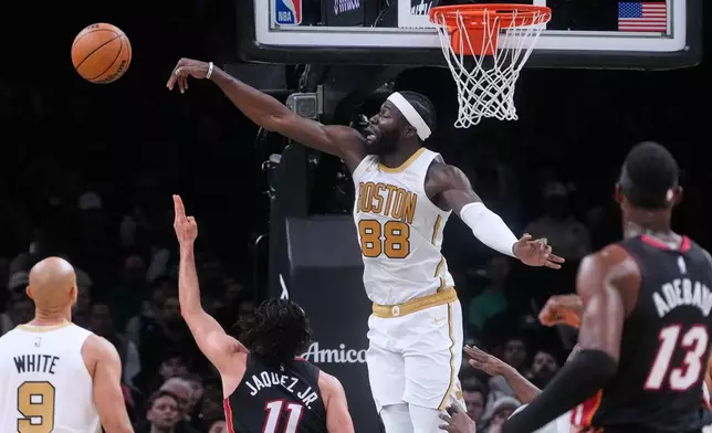 Boston Celtics center Neemias Queta (88) blocks a shot by Miami Heat forward Jaime Jaquez Jr. (11) during the first half of an NBA basketball game, Friday, Dec. 19, 2025, in Boston. (AP Photo/Charles Krupa)