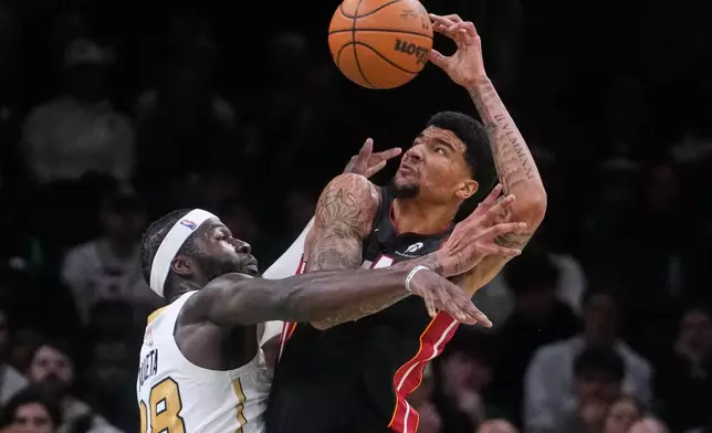 Boston Celtics center Neemias Queta, left, battles for the ball against Miami Heat center Kel'El Ware, right, during the first half of an NBA basketball game, Friday, Dec. 19, 2025, in Boston. (AP Photo/Charles Krupa)