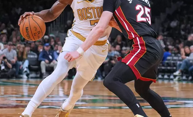 Boston Celtics guard Jaylen Brown, left, drives to the basket against Miami Heat guard Kasparas Jakucionis (25) during the first half of an NBA basketball game, Friday, Dec. 19, 2025, in Boston. (AP Photo/Charles Krupa)