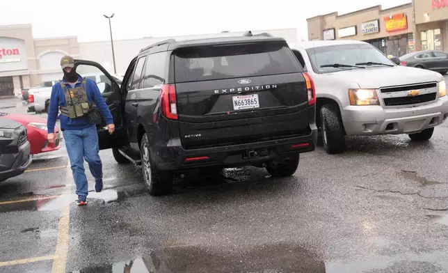 A Customs and Border Protection agent exits a vehicle after agents apprehended two people during an operation Thursday, Dec. 4, 2025, in Kenner, La. (AP Photo/Gerald Herbert)