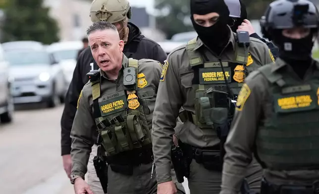 Customs and Border Patrol commander Gregory Bovino walks with border patrol agents through a neighborhood during an immigration crackdown, in Kenner, La., Friday, Dec. 5, 2025. (AP Photo/Gerald Herbert)