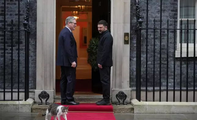 Britain's Prime Minister Keir Starmer greets Ukrainian President Volodymyr Zelenskyy, on the doorstep of 10 Downing Street, London, Monday, Dec. 8, 2025, Larry the cat, Chief Mouser to the Cabinet Office walks past. (AP Photo/Kin Cheung)
