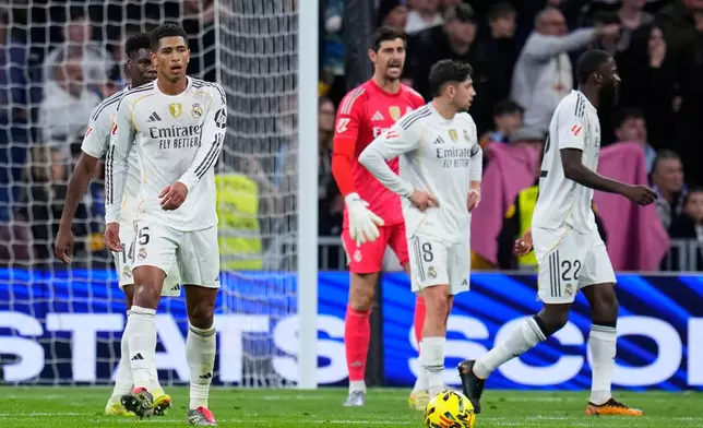 Real Madrid's Jude Bellingham, left, and teammates react after Celta's Williot Swedberg scored his side's second goal during the Spanish La Liga soccer match between Real Madrid and Celta Vigo in Madrid, Spain, Sunday, Dec. 7, 2025. (AP Photo/Manu Fernandez)