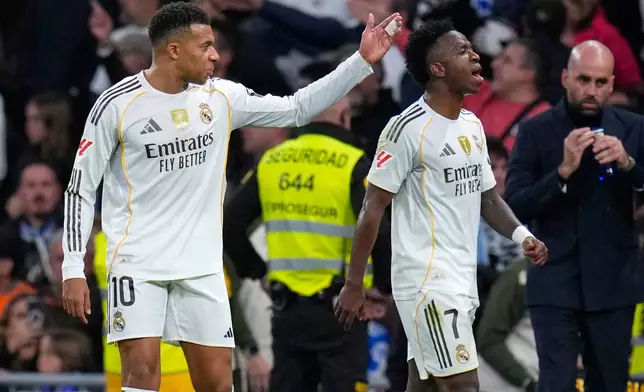 Real Madrid's Kylian Mbappe, left, and Vinicius Junior react during the Spanish La Liga soccer match between Real Madrid and Celta Vigo in Madrid, Spain, Sunday, Dec. 7, 2025. (AP Photo/Manu Fernandez)