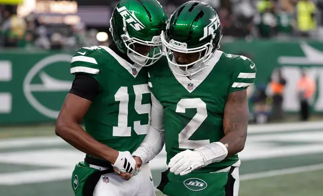 New York Jets wide receiver Adonai Mitchell (15) celebrates his touchdown with quarterback Tyrod Taylor (2) against the Atlanta Falcons during the second half of an NFL football game, Sunday, Nov. 30, 2025, in East Rutherford, N.J. (AP Photo/Adam Hunger)