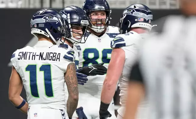 Seattle Seahawks wide receiver Cooper Kupp, second from left, celebrates his touchdown with teammates Jaxon Smith-Njigba (11) and Nick Kallerup (89) against the Atlanta Falcons during the second half of an NFL football game, Sunday, Dec. 7, 2025, in Atlanta. (AP Photo/Brynn Anderson)