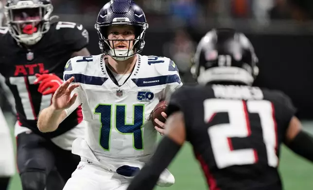 Seattle Seahawks quarterback Sam Darnold (14) runs the ball against Atlanta Falcons cornerback Mike Hughes (21) during the second half of an NFL football game, Sunday, Dec. 7, 2025, in Atlanta. (AP Photo/Brynn Anderson)