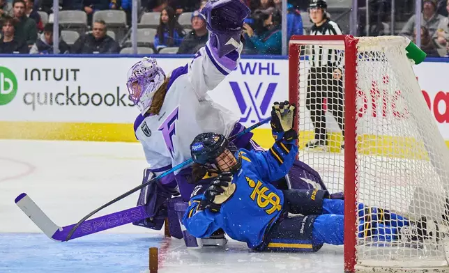 Toronto Sceptres' Blayre Turnbull (40) crashes into the net as she collides with Minnesota Frost goaltender Nicole Hensley (29) during the second period of an PWHL hockey game in Toronto, on Tuesday, Dec. 30, 2025. (Sammy Kogan/The Canadian Press via AP)