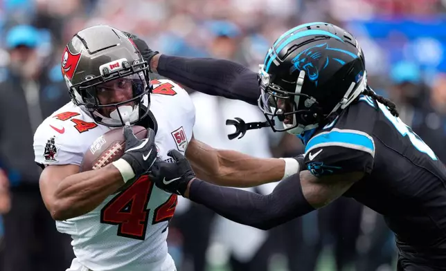 Tampa Bay Buccaneers running back Sean Tucker is tackled by Carolina Panthers cornerback Jaycee Horn during the first half of an NFL football game, Sunday, Dec. 21, 2025, in Charlotte, N.C. (AP Photo/Jacob Kupferman)