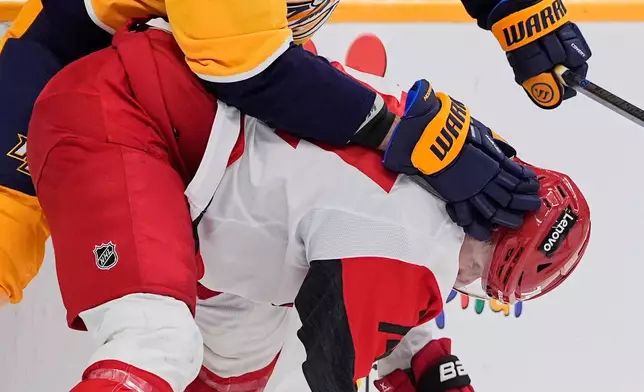 Nashville Predators right wing Michael McCarron (47) and Carolina Hurricanes defenseman Jaccob Slavin, right, battle for loose puck during the second period of an NHL hockey game Wednesday, Dec. 17, 2025, in Nashville, Tenn. (AP Photo/George Walker IV)