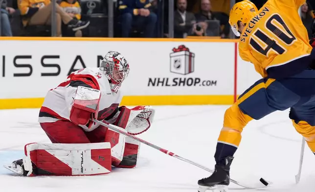 Carolina Hurricanes goaltender Pyotr Kochetkov (52) defends the goal against Nashville Predators center Fedor Svechkov (40) during the second period of an NHL hockey game Wednesday, Dec. 17, 2025, in Nashville, Tenn. (AP Photo/George Walker IV)