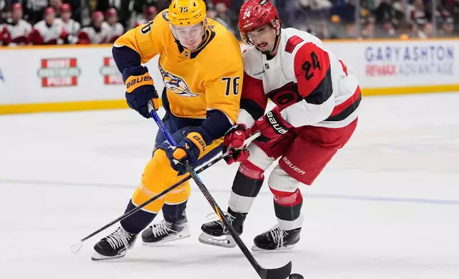 Nashville Predators defenseman Brady Skjei (76) moves the puck past Carolina Hurricanes center Seth Jarvis (24) during the first period of an NHL hockey game Wednesday, Dec. 17, 2025, in Nashville, Tenn. (AP Photo/George Walker IV)
