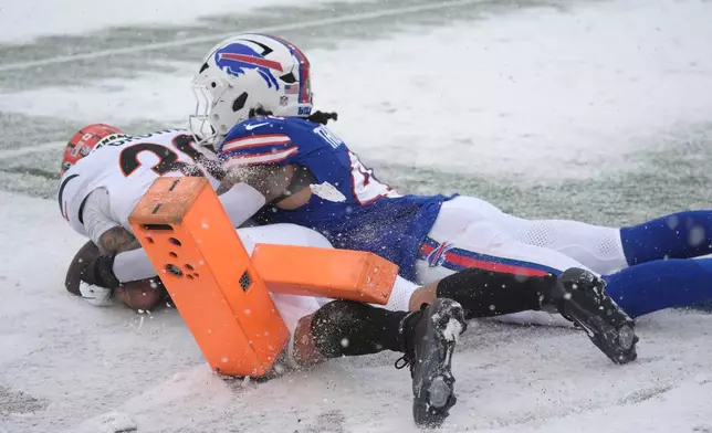 Cincinnati Bengals running back Chase Brown (30) scores a touchdown as Buffalo Bills linebacker Shaq Thompson (45) defends during the first half of an NFL football game, Sunday, Dec. 7, 2025, in Orchard Park, N.Y. (AP Photo/Gene J. Puskar)