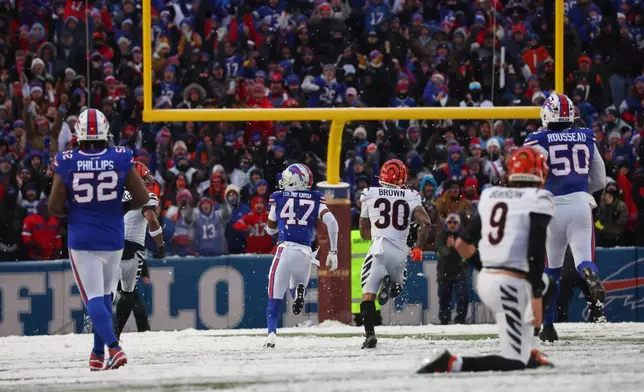 Buffalo Bills cornerback Christian Benford (47) runs for a touchdown after intercepting a pass by Cincinnati Bengals quarterback Joe Burrow (9) during the second half of an NFL football game, Sunday, Dec. 7, 2025, in Orchard Park, N.Y. Also seen are Buffalo Bills defensive tackle Jordan Phillips (52), Cincinnati Bengals running back Chase Brown (30) and Buffalo Bills defensive end Greg Rousseau (50). (AP Photo/Jeffrey T. Barnes)