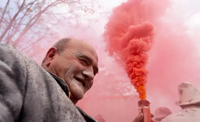 A reveller takes part in the Els Enfarinats festival, a battle using flour, eggs and firecrackers, in the town of Ibi near Alicante, Spain, Sunday Dec. 28, 2025. (AP Photo/Alberto Saiz)