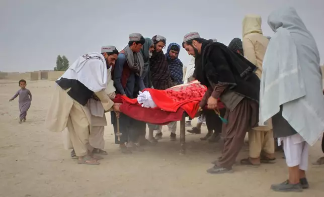 Afghans prepare the body of a man killed during an overnight exchange of fire between Afghan and Pakistani forces along the border in Spin Boldak, Kandahar province, Afghanistan, Saturday, Dec. 6, 2025. (AP Photo/Sibghatullah)