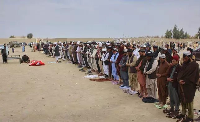 Afghans pray during the funeral of a man killed during an overnight exchange of fire between Afghan and Pakistani forces along the border in Spin Boldak, Kandahar province, Afghanistan, Saturday, Dec. 6, 2025. (AP Photo/Sibghatullah)