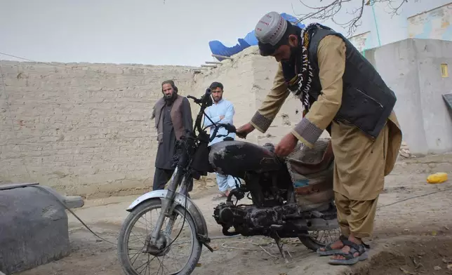 A man inspects a motorcycle damaged during an overnight exchange of fire between Afghan and Pakistani forces along the border in Spin Boldak, Kandahar province, Afghanistan, Saturday, Dec. 6, 2025. (AP Photo/Sibghatullah)