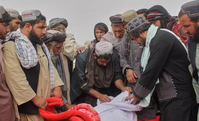 Afghans prepare the body of a man killed during an overnight exchange of fire between Afghan and Pakistani forces along the border in Spin Boldak, Kandahar province, Afghanistan, Saturday, Dec. 6, 2025. (AP Photo/Sibghatullah)