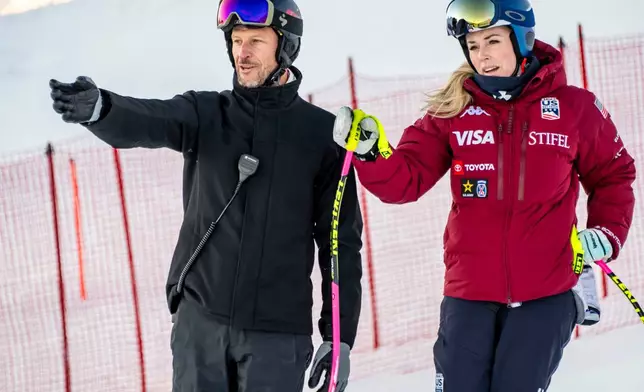 Lindsey Vonn, right, of the United States, and Coach and former Norwegian skier Aksel Lund Svindal, left, talk before the women's Downhill training race at the Alpine Skiing FIS Ski World Cup in St. Moritz, Switzerland, Wednesday, Dec. 10, 2025. (Jean-Christophe Bott/Keystone via AP)