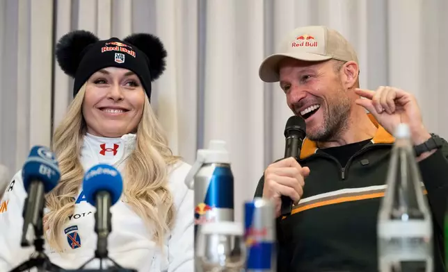 Coach and former Norwegian skier Aksel Lund Svindal, right, speaks with Lindsey Vonn, of the United States, during a press conference ahead of the women's World Cup downhill race Wednesday, Dec. 10, 2025 at the hotel Kempinski in St. Moritz, Switzerland. (Claudio Thoma/Keystone via AP)