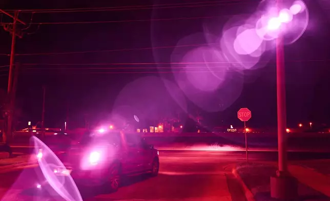 An infrared beam of light shines out of an automatic license plate reader as it records vehicles driving by, Oct. 13, 2025, in Laredo, Texas. (AP Photo/David Goldman)