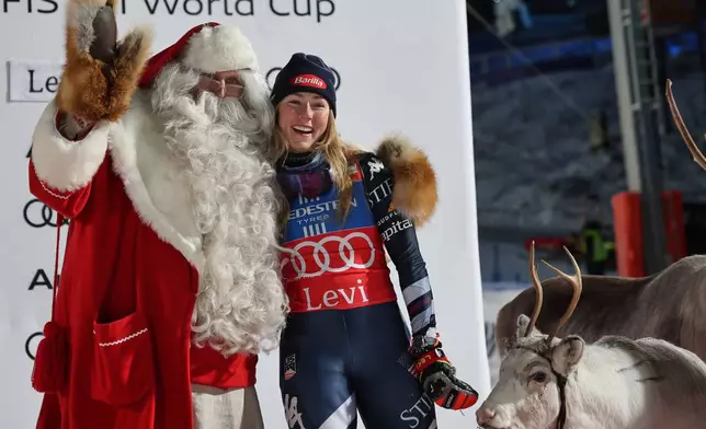 FILE - United States' Mikaela Shiffrin poses with Santa Claus as she celebrates on the podium after winning an alpine ski, women's World Cup slalom, in Levi, Finland, on Nov. 15, 2025. (AP Photo/Marco Trovati, File)