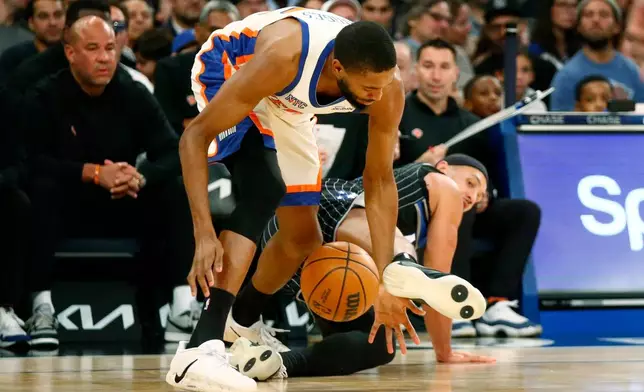 New York Knicks guard Mikal Bridges goes for a loose ball as Orlando Magic guard Jalen Suggs defends during the first half of an NBA basketball game Sunday, Dec. 7, 2025, in New York. (AP Photo/John Munson)