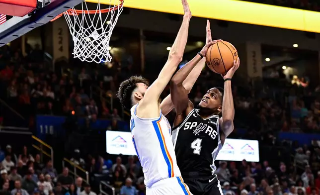 San Antonio Spurs guard De'Aaron Fox (4) shoots against Oklahoma City Thunder Chet Holmgren (7) during the first half of an NBA basketball game, Thursday, Dec. 25, 2025, in Oklahoma City. (AP Photo/Gerald Leong)