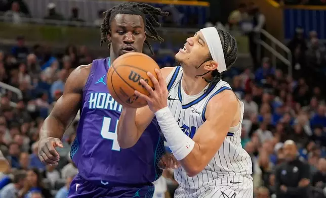 Orlando Magic guard Anthony Black, right, looks for a shot against Charlotte Hornets guard Sion James (4) during the first half of an NBA basketball game, Friday, Dec. 26, 2025, in Orlando, Fla. (AP Photo/John Raoux)