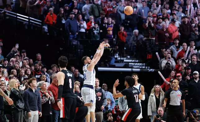 Dallas Mavericks guard Klay Thompson, middle, shoots during the second half of an NBA basketball game against the Portland Trail Blazers Monday Dec. 29, 2025, in Portland, Ore. (AP Photo/Howard Lao)