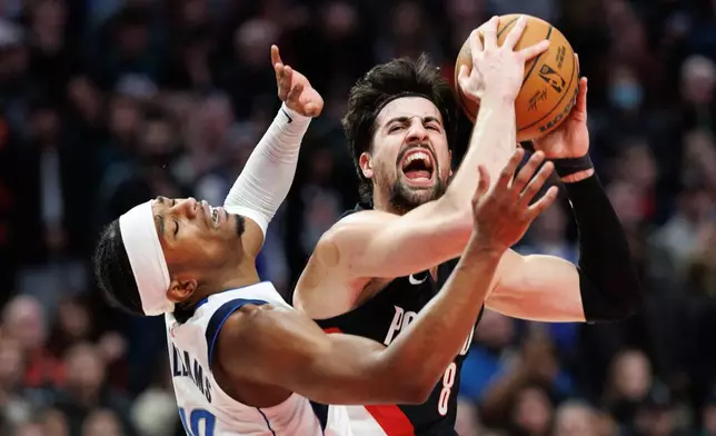 Portland Trail Blazers forward Deni Avdija, right, drives to the basket against Dallas Mavericks guard Brandon Williams, left, during the second half of an NBA basketball game Monday Dec. 29, 2025, in Portland, Ore. (AP Photo/Howard Lao)