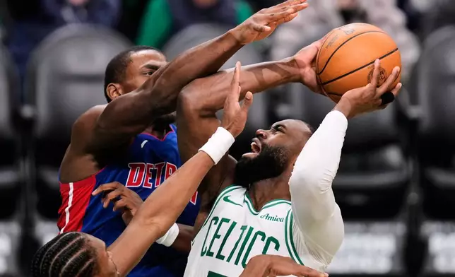 Boston Celtics guard Jaylen Brown, right, is covered by Detroit Pistons guard Ausar Thompson, top left, on a drive to the basket during the second half of an NBA basketball game, Monday, Dec. 15, 2025, in Boston. (AP Photo/Charles Krupa)