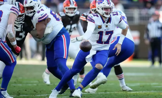 Buffalo Bills quarterback Josh Allen (17) hands off against the Buffalo Bills during the second half of an NFL football game in Cleveland, Sunday, Dec. 21, 2025. (AP Photo/Sue Ogrocki)