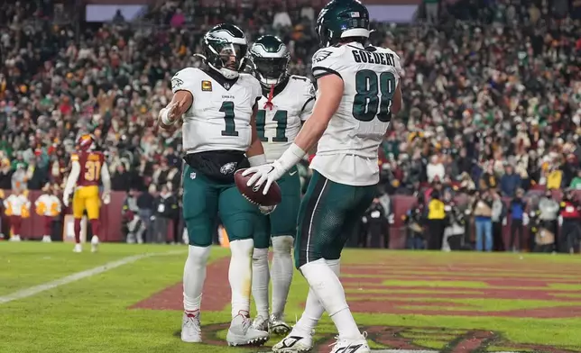 Philadelphia Eagles tight end Dallas Goedert (88) celebrates with quarterback Jalen Hurts (1) after scoring a touchdown against the Washington Commanders during the second half of an NFL football game, Saturday, Dec. 20, 2025, in Landover, Md. (AP Photo/Stephanie Scarbrough)