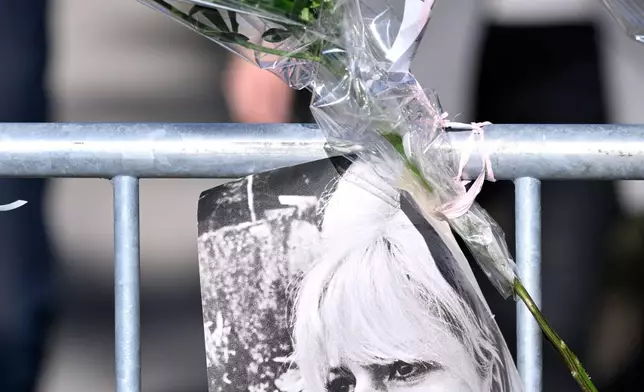 A poster showing actor Brigitte Bardot and flowers hang near Brigitte Bardot's home in Saint-Tropez, southern France, Sunday, Dec. 28, 2025 after the French 1960s sex symbol who became one of the greatest screen sirens of the 20th century and later a militant animal rights activist and far-right supporter, has died. She was 91. (AP Photo/Philippe Magoni)