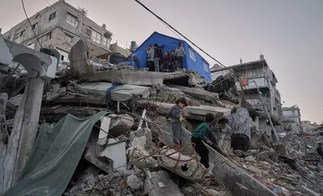 Children from the Abu Duheir family step down from their temporary tent, erected over the rubble of their collapsed home in the Sheikh Radwan neighborhood of Gaza City, Wednesday, Nov. 26, 2025. (AP Photo/Jehad Alshrafi)