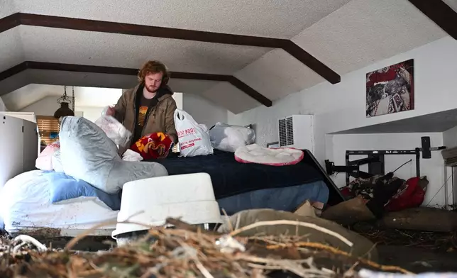 Davey Schneider recovers items from his storm-damaged home on Thursday, Dec. 25, 2025, in Wrightwood, Calif. (AP Photo/William Liang)