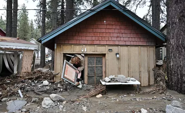 Davey Schneider recovers items from his storm damaged home on Thursday, Dec. 25, 2025, in Wrightwood, Calif. (AP Photo/William Liang)