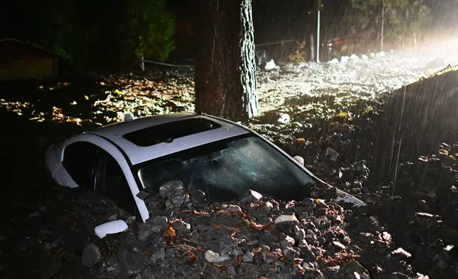 A car sits buried in mud after flooding Wednesday, Dec. 24, 2025, in Wrightwood, Calif. (AP Photo/Wally Skalij)