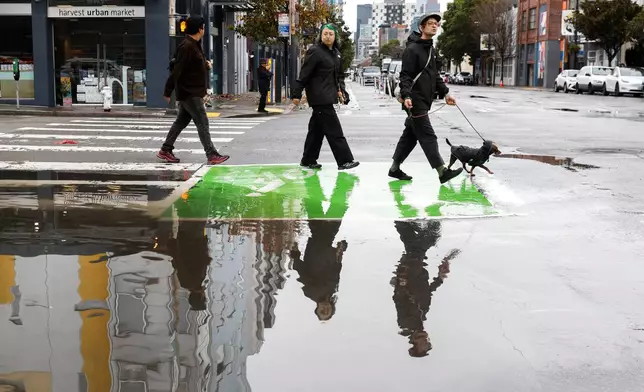 Heavy rains cause flooding in the streets of San Francisco, Monday, Dec. 22, 2025, as a storm system pummels Northern California. (Jessica Christian/San Francisco Chronicle via AP)