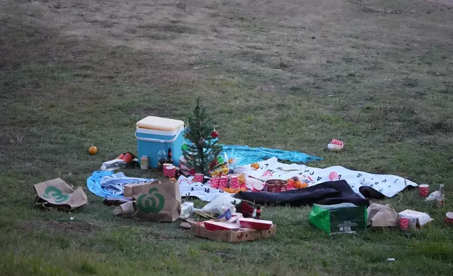 A small Christmas tree is at the center of an abandoned holiday picnic at Bondi Beach after a reported shooting in Sydney, Sunday, Dec. 14, 2025. (AP Photo/Mark Baker)