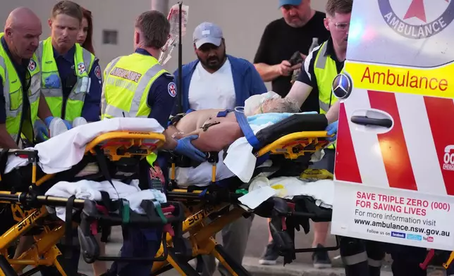Emergency workers transport a person on a stretcher after a reported shooting at Bondi Beach in Sydney, Sunday, Dec. 14, 2025. (AP Photo/Mark Baker)