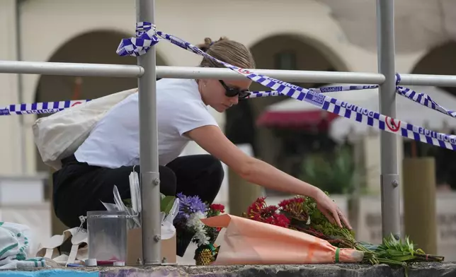 Shenna McClean lays flowers at a memorial at Sydney's Bondi Beach, Monday, Dec. 15, 2025, a day after a shooting. (AP Photo/Mark Baker)