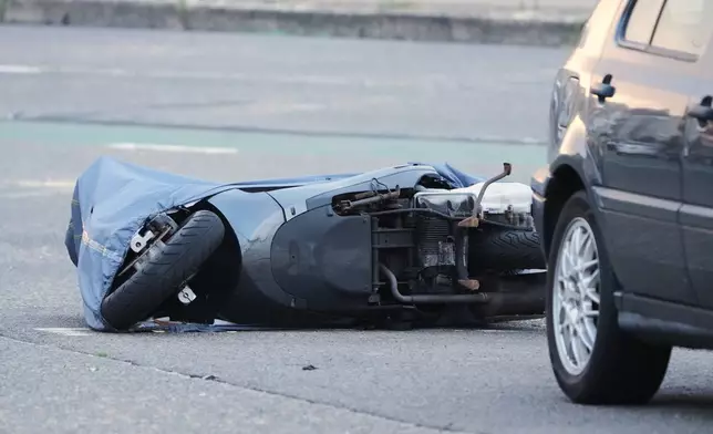 A motorcycle lies on the ground in the early morning near the site of a shooting Sunday at Sydney's Bondi Beach, Monday, Dec. 15, 2025. (AP Photo/Mark Baker)