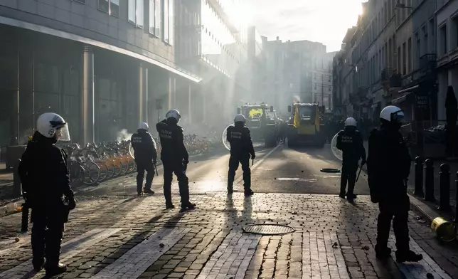 Police try to disperse protestors during a demonstration of European farmers near the European Parliament in Brussels, Thursday, Dec. 18, 2025. (AP Photo/Marius Burgelman)