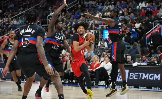 Portland Trail Blazers guard Shaedon Sharpe, second from right, drives against Detroit Pistons forward Ronald Holland II, forward Isaiah Stewart, and guard Caris LeVert, from left, during the first half of an NBA basketball game Friday, Dec. 5, 2025, in Detroit. (AP Photo/Ryan Sun)