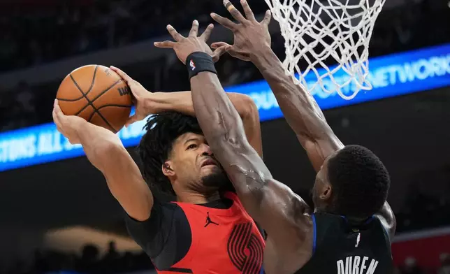 Portland Trail Blazers guard Shaedon Sharpe, left, drives against Detroit Pistons center Jalen Duren during the first half of an NBA basketball game, Friday, Dec. 5, 2025, in Detroit. (AP Photo/Ryan Sun)
