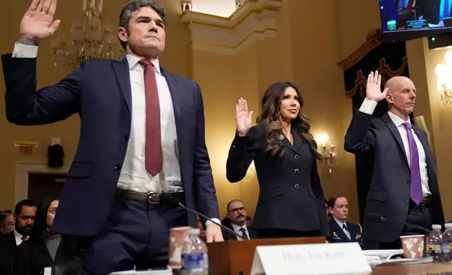 From left, Joseph Kent, director of the National Counterterrorism Center, Homeland Security Secretary Kristi Noem, and Michael Glasheen, operations director of the National Security Branch of the FBI, raise their arms before the House Committee on Homeland Security on Capitol Hill in Washington, Thursday, Dec. 11, 2025. (AP Photo/Mark Schiefelbein)