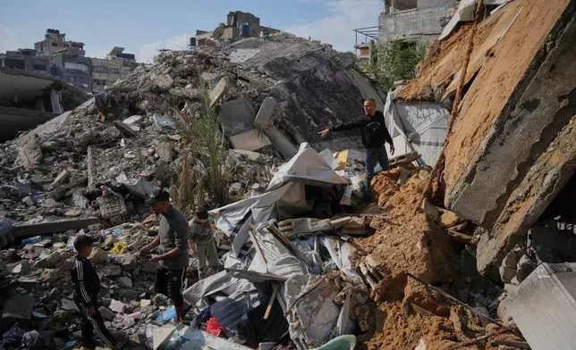 Members of the Al-Hosari family check the rubble looking for their belongings after their house collapsed, killing, according to Al-Shafa Hospital officials, at least one person and leaving several others injured in Gaza City, Tuesday, Dec. 16, 2025. (AP Photo/Abdel Kareem Hana)